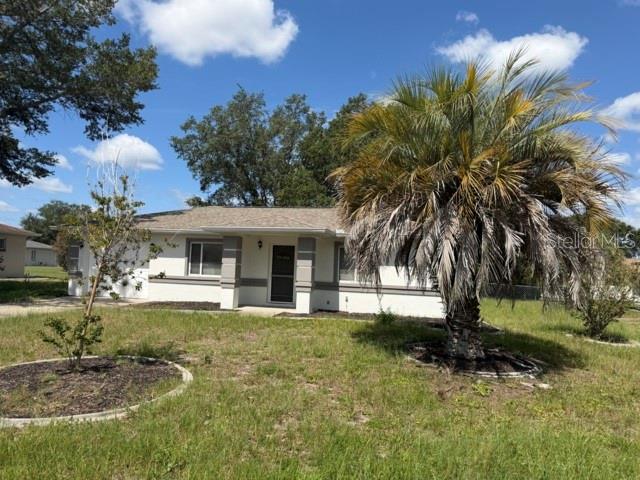 A single-story house with a palm tree in the front yard under a blue sky — 9842 SW 61ST TERRACE, OCALA, FL