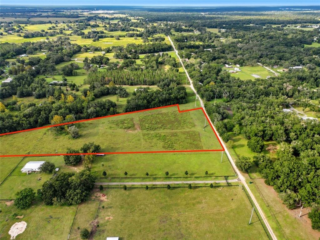 An aerial view shows a large, fenced plot of land outlined in red — 0 POWERLINE ROAD, DADE CITY, FL