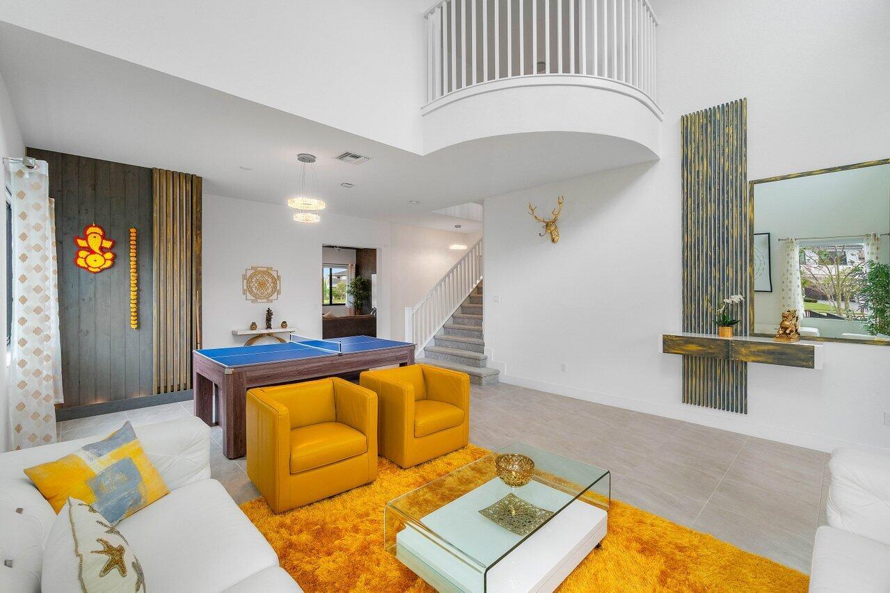 A living room features a ping pong table, yellow armchairs, and a bright yellow rug — 10780 Oceano Way, Parkland FL 33076, PARKLAND, FL