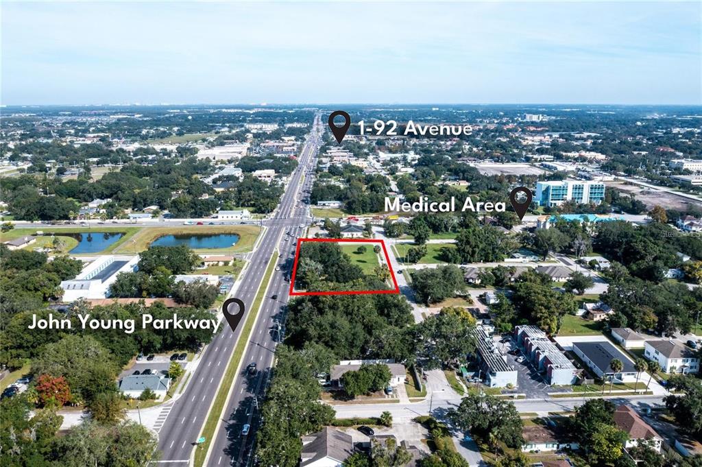 This aerial view shows a vacant lot outlined in red along a major roadway — 0 JOHN YOUNG PARKWAY, KISSIMMEE, FL