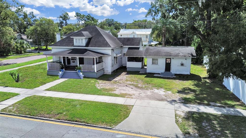An aerial view shows a white house with a porch and a detached garage — 601 W BAKER STREET, PLANT CITY, FL