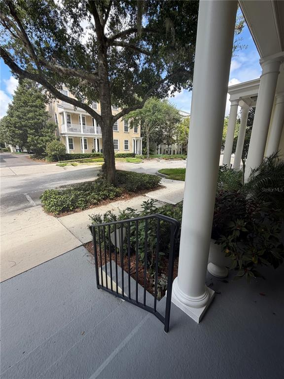 A view from a porch with white columns looking out toward a street and buildings — 1425 CHATFIELD PLACE, ORLANDO, FL