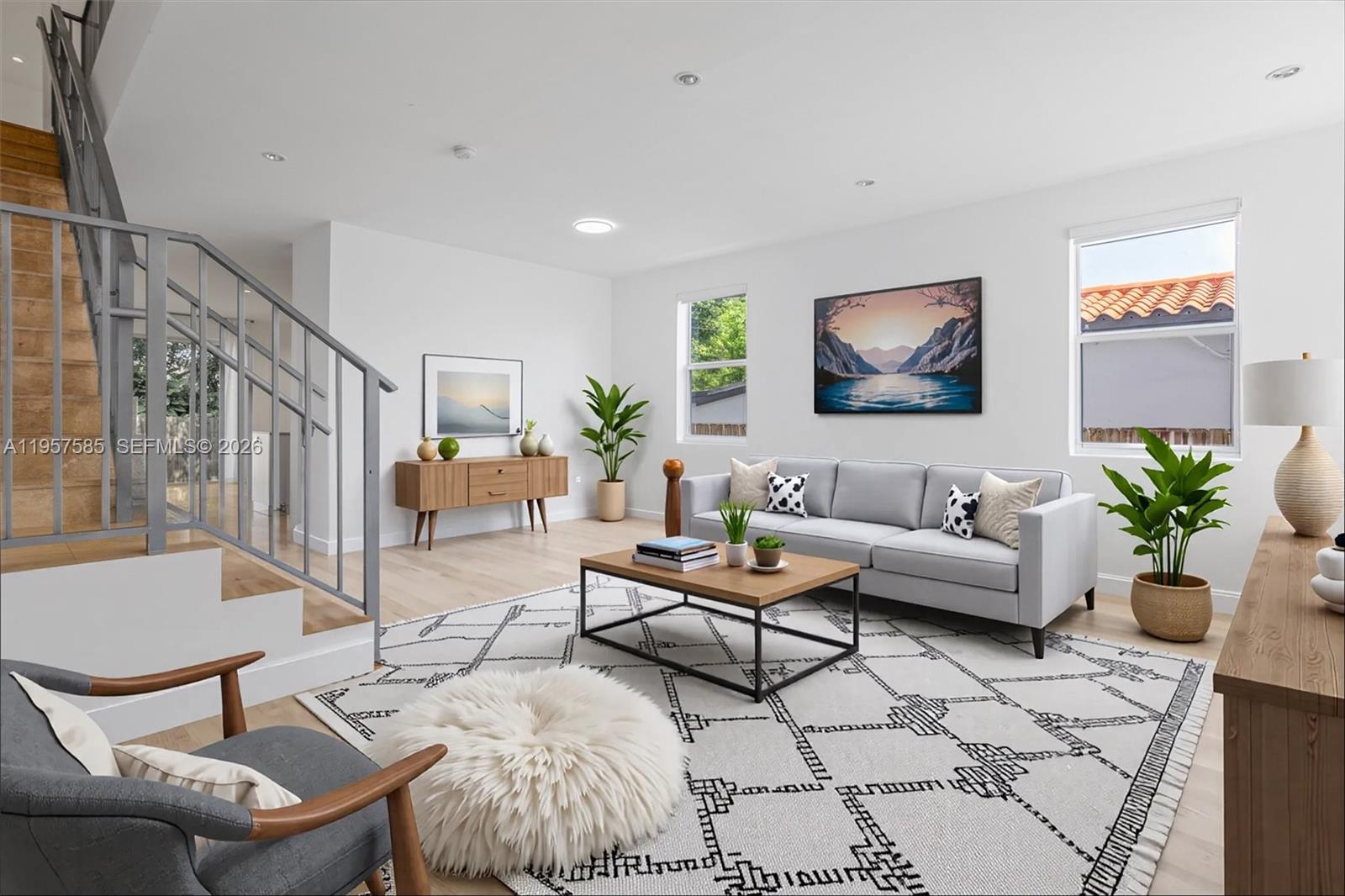 A living room features a grey sofa, a patterned rug, and a staircase with railings — 2784 SW 34th Ave, Miami FL 33133, MIAMI, FL