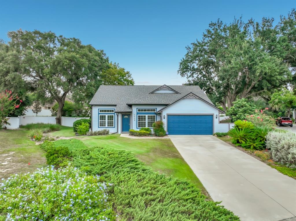 A single-story house with light blue siding, a blue garage door, and a concrete driveway — 6609 PINEKNOT COURT, OCOEE, FL