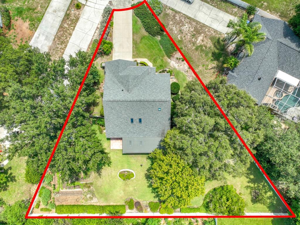 An aerial view shows a house with a gray roof on a triangular-shaped lot — 6609 PINEKNOT COURT, OCOEE, FL