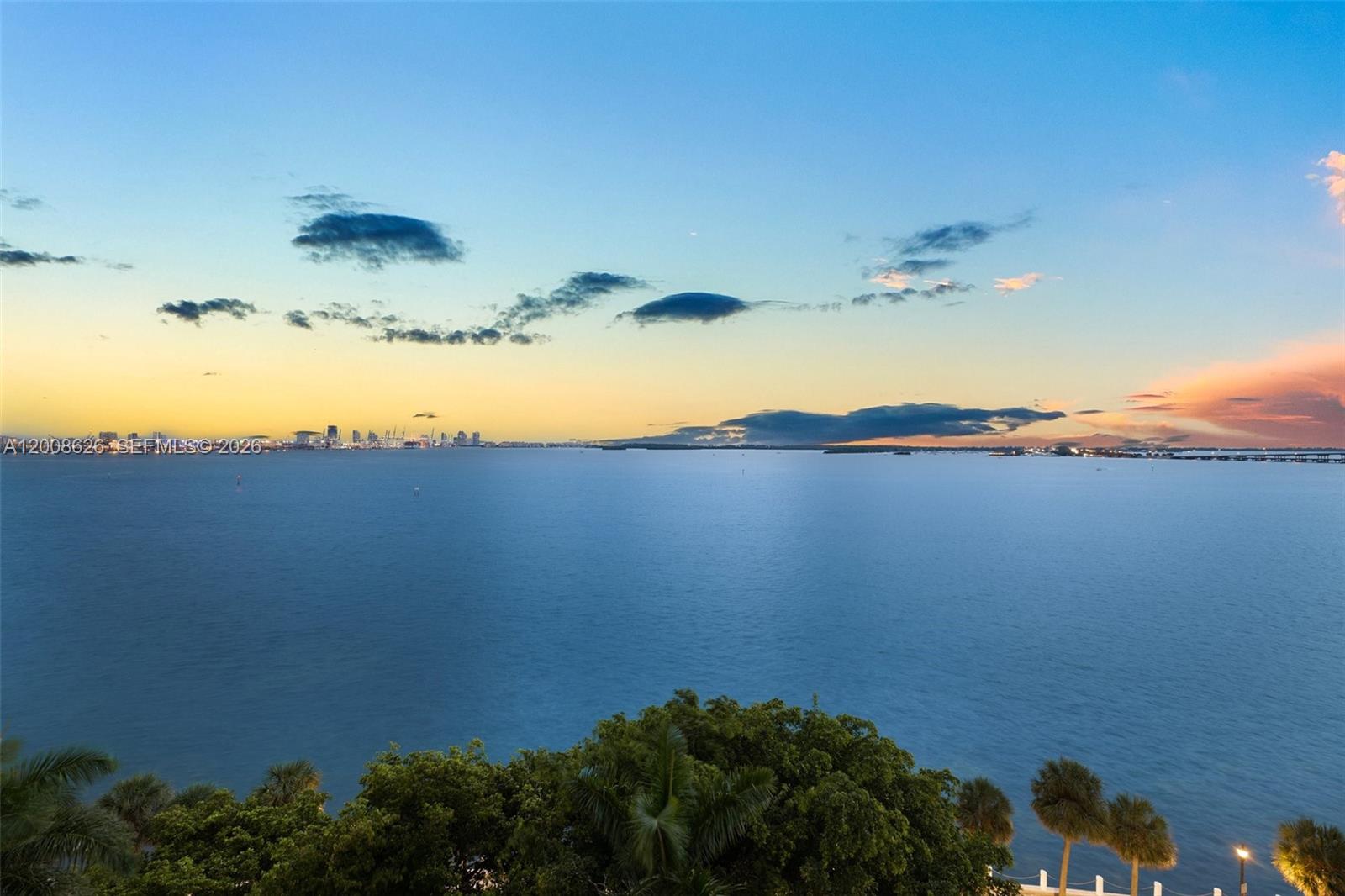 A wide view of a calm bay at sunset with a distant city skyline — 1420 Brickell Bay Dr # 1001A, Miami FL 33131, MIAMI, FL