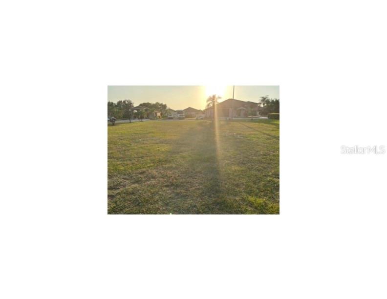 A grassy, vacant residential lot is shown under a bright, sunny sky — 440 NOLANE LANE, POLK CITY, FL