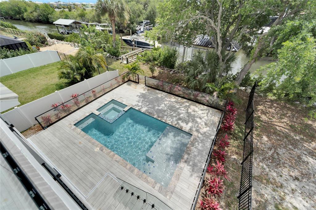 An elevated view of a backyard pool and spa with a glass fence and deck — 534 ESTUARY SHORE LANE, APOLLO BEACH, FL
