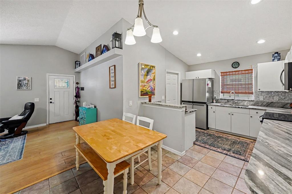A kitchen and dining area with light wood floors, tile, and a breakfast bar — 1934 29TH AVENUE N, ST PETERSBURG, FL