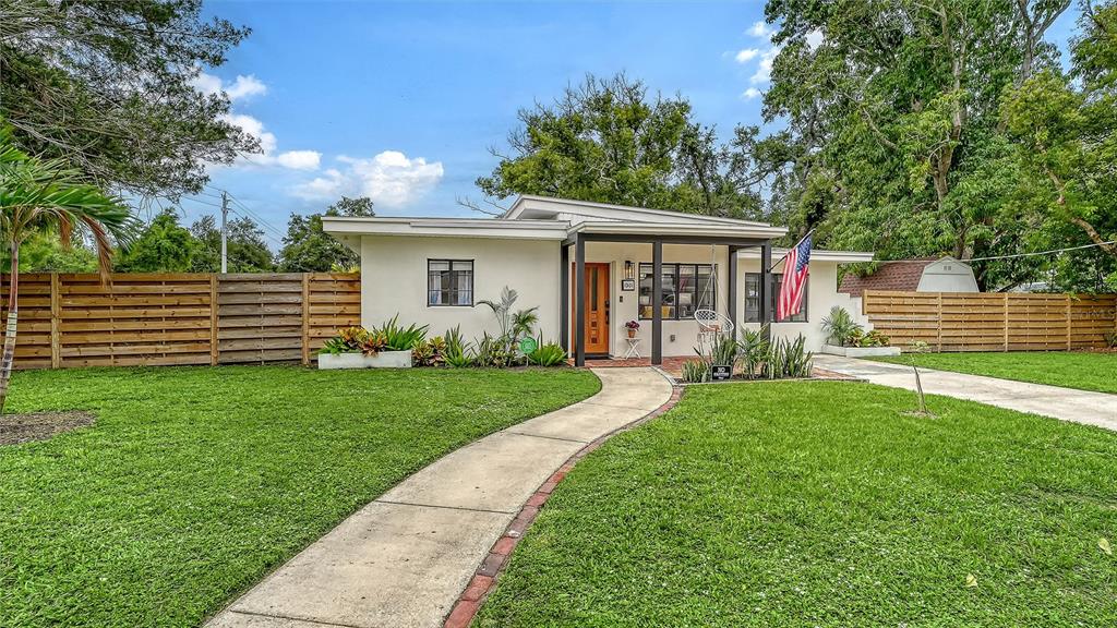 A single-story house with a flat roof, wooden fence, and a concrete walkway — 1301 6TH STREET W, PALMETTO, FL