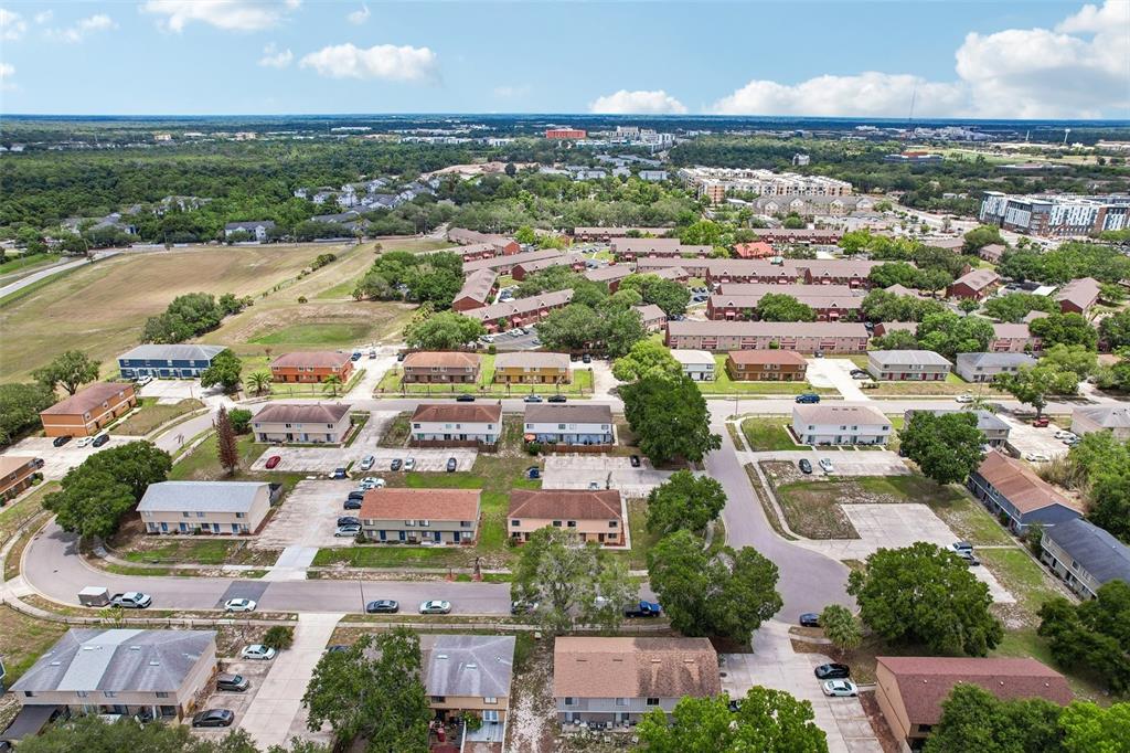 An aerial view shows multiple two-story apartment buildings surrounded by parking lots and green spaces — 12057 TIFT CIRCLE, ORLANDO, FL