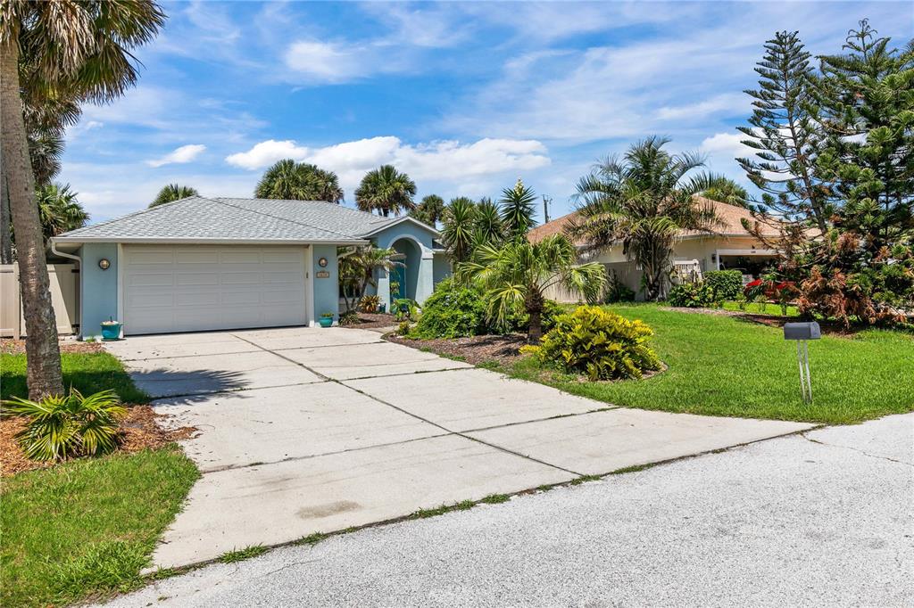 A light blue single-story house with a concrete driveway and a two-car garage — 4610 DORIS DRIVE, NEW SMYRNA BEACH, FL