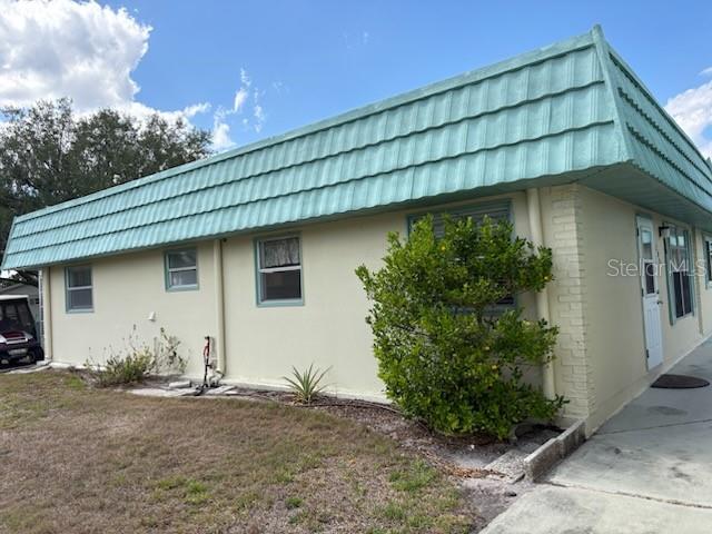 A single-story building exterior features a light green mansard roof and a white front door — 101 CAMBRIDGE TRAIL UNIT 200, SUN CITY CENTER, FL