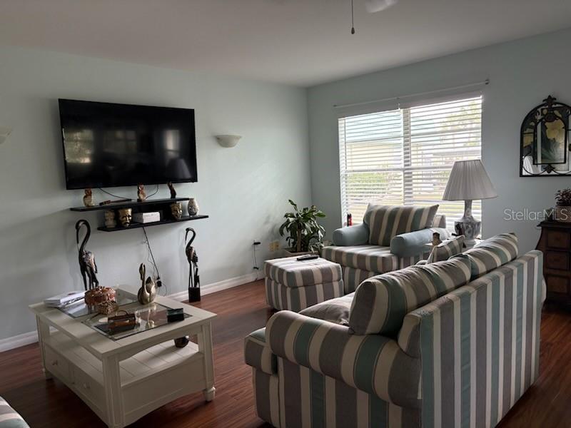The exterior of a single-story building features a light-colored wall, a white door, and teal shutters — 101 CAMBRIDGE TRAIL UNIT 200, SUN CITY CENTER, FL