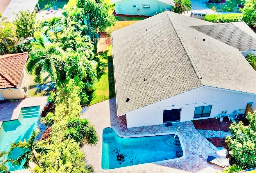 An aerial view shows a house with a shingled roof and two swimming pools — 17768 Maplewood Drive, Boca Raton FL 33487, BOCA RATON, FL