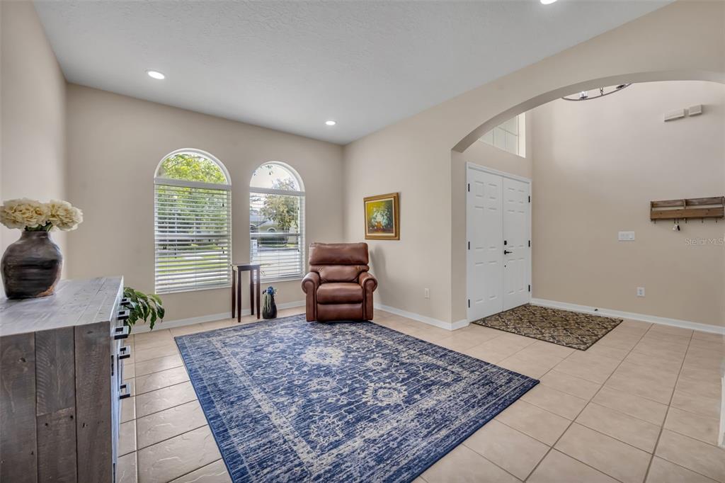 A living room with a leather recliner, wooden coffee table, and an adjacent dining area — 1502 ASHDOWN COURT, SANFORD, FL