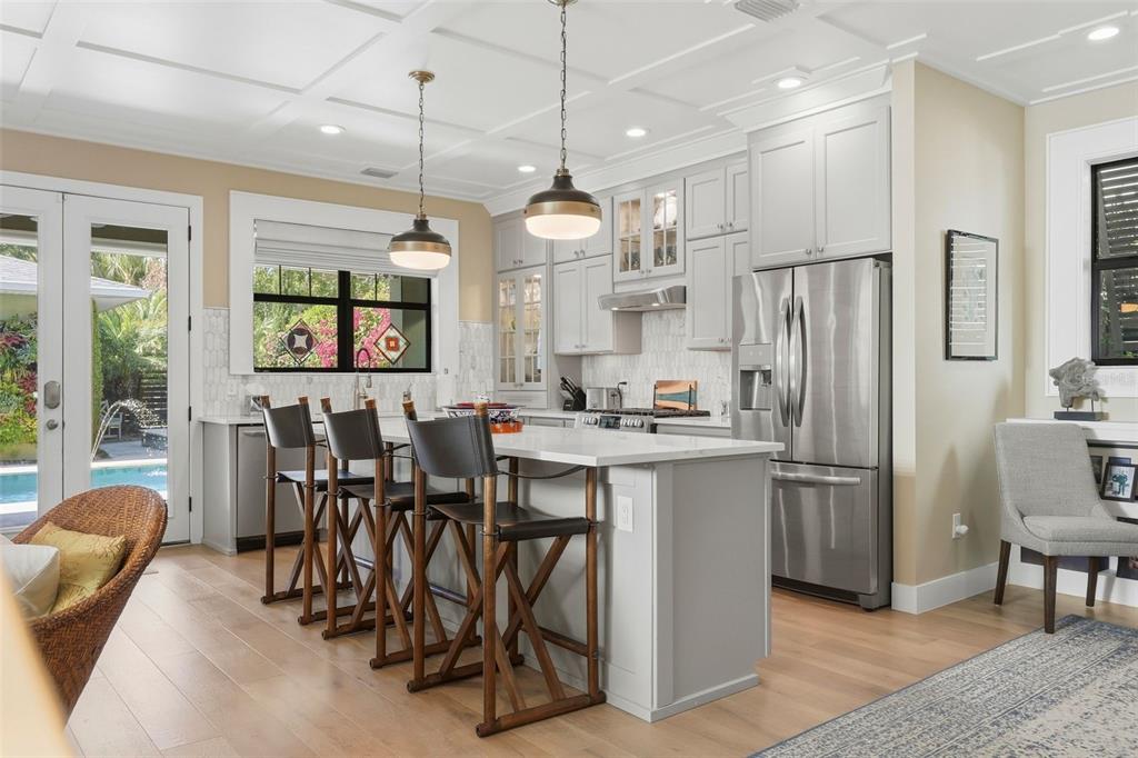 A kitchen with a white island, bar stools, stainless steel appliances, and light wood floors — 2344 2ND AVENUE N, ST PETERSBURG, FL