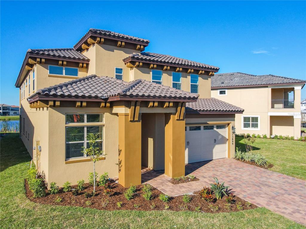 A two-story stucco house with a tile roof and a paved driveway — 13899 LARKTON LANE, ORLANDO, FL