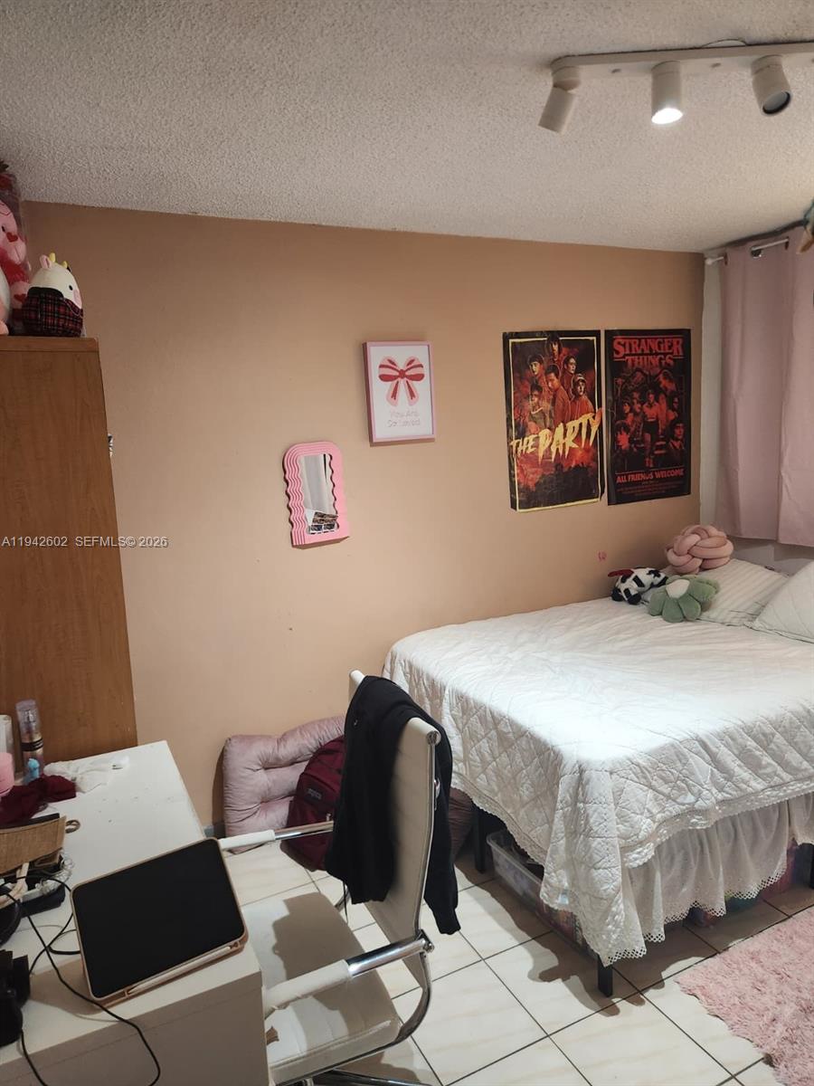 A bedroom features a bed, a desk with a chair, and posters on the wall — 2498 SW 17th Ave # 4209, Miami FL 33145, MIAMI, FL