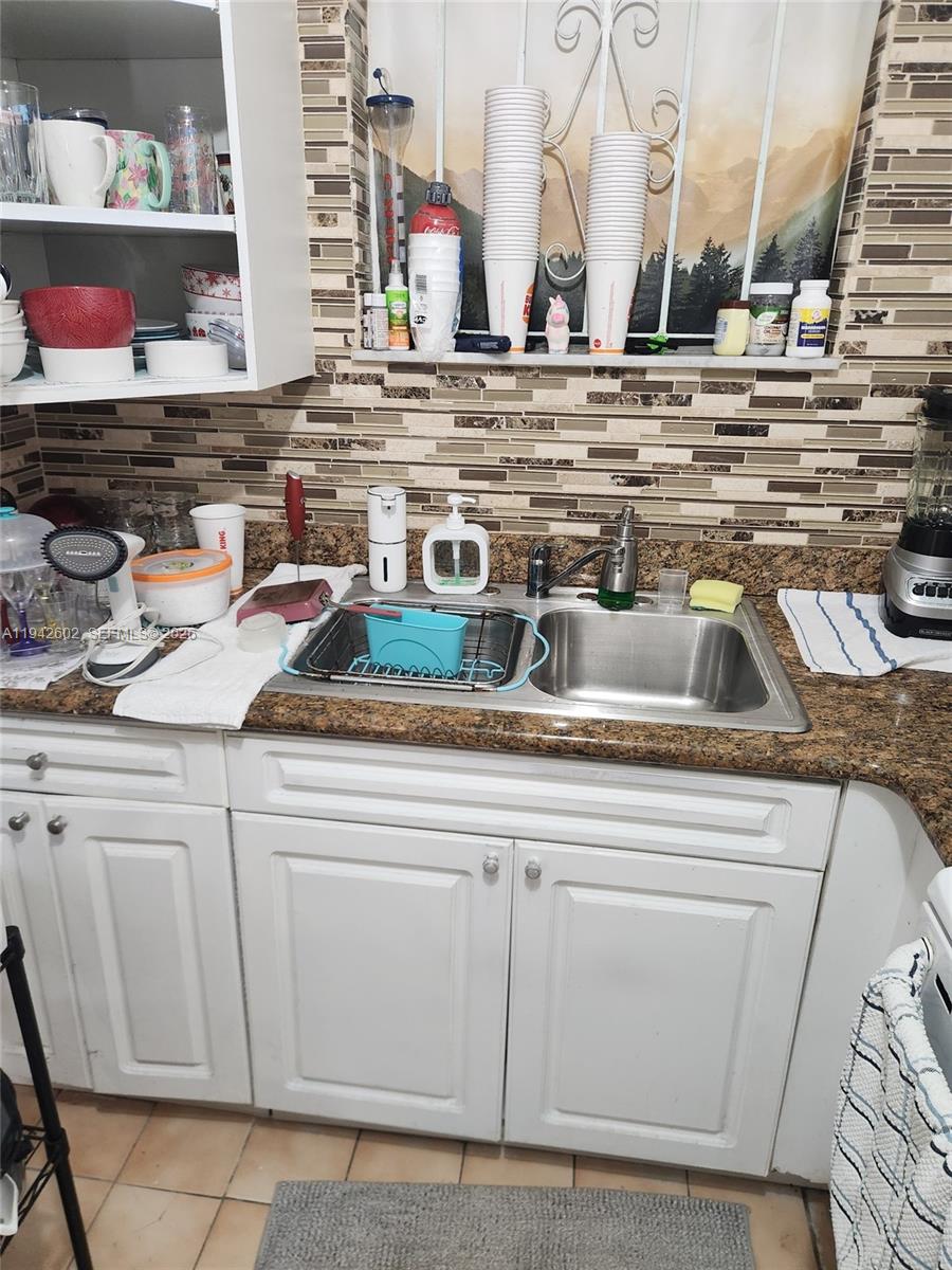 A kitchen sink area features white cabinets, a granite countertop, and a tiled backsplash — 2498 SW 17th Ave # 4209, Miami FL 33145, MIAMI, FL