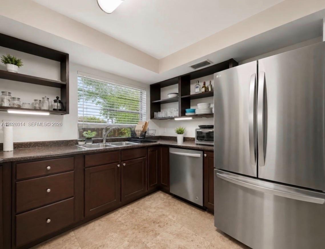 A kitchen features dark wood cabinets, stainless steel appliances, open shelving, and a window — 11105 SW 132nd Ct # 4, Miami FL 33186, MIAMI, FL