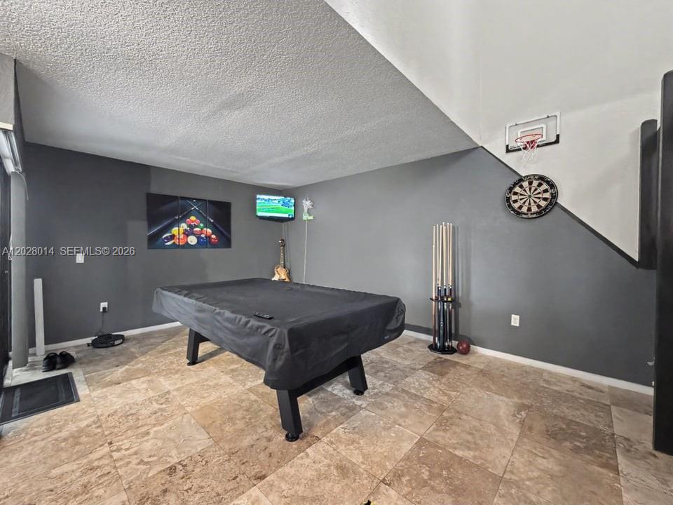 A game room features a covered pool table, a dartboard, and a small basketball hoop — 11105 SW 132nd Ct # 4, Miami FL 33186, MIAMI, FL