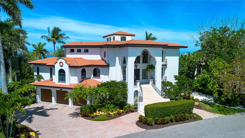 A large, multi-story white villa with a red tile roof and a grand staircase entrance — 12925 42ND TERRACE W, CORTEZ, FL