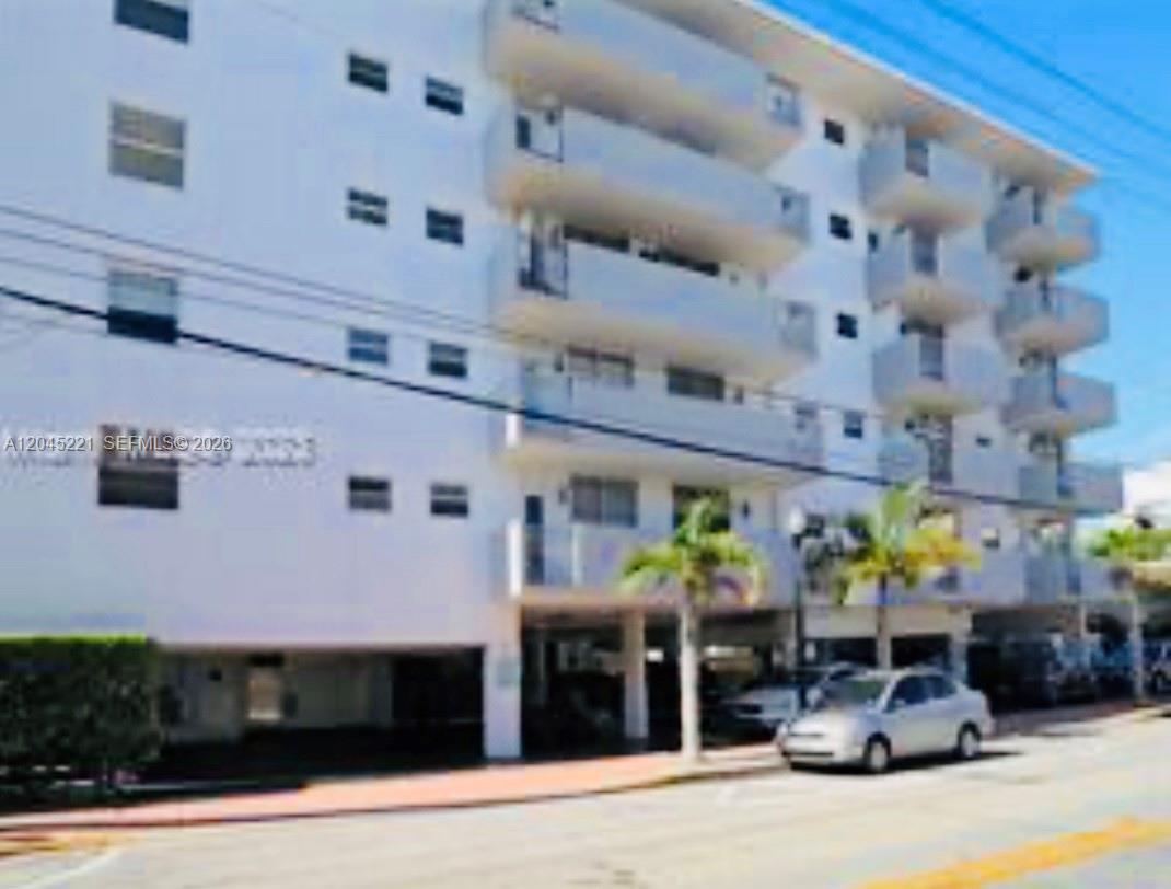 A multi-story white apartment building features balconies and a ground-level parking area — 360 Meridian Ave # 4A, Miami Beach FL 33139, MIAMI BEACH, FL