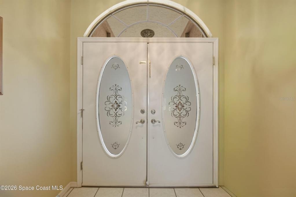 A double front door with oval glass inserts and a semi-circular transom window above — 4562 HELENA DRIVE, TITUSVILLE, FL