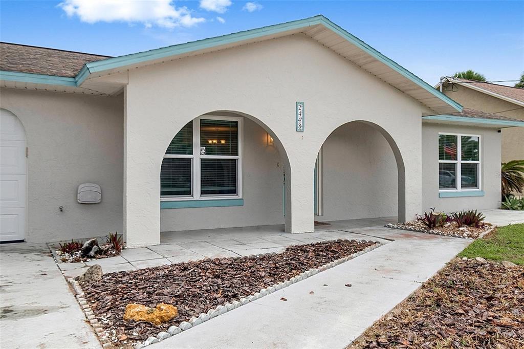 A single-story house exterior features a covered porch with two large arches and light-colored stucco — 2448 S DAYTONA AVENUE, FLAGLER BEACH, FL