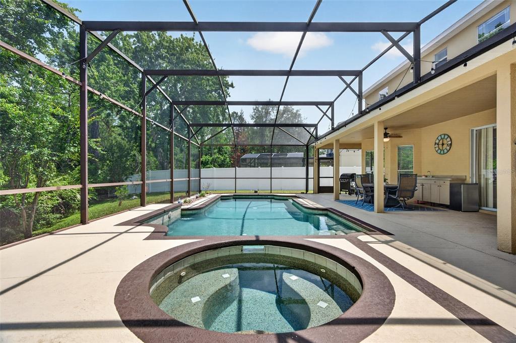 A screened-in patio features a swimming pool, a circular hot tub, and a covered porch — 1880 OAK GROVE CHASE DRIVE, ORLANDO, FL