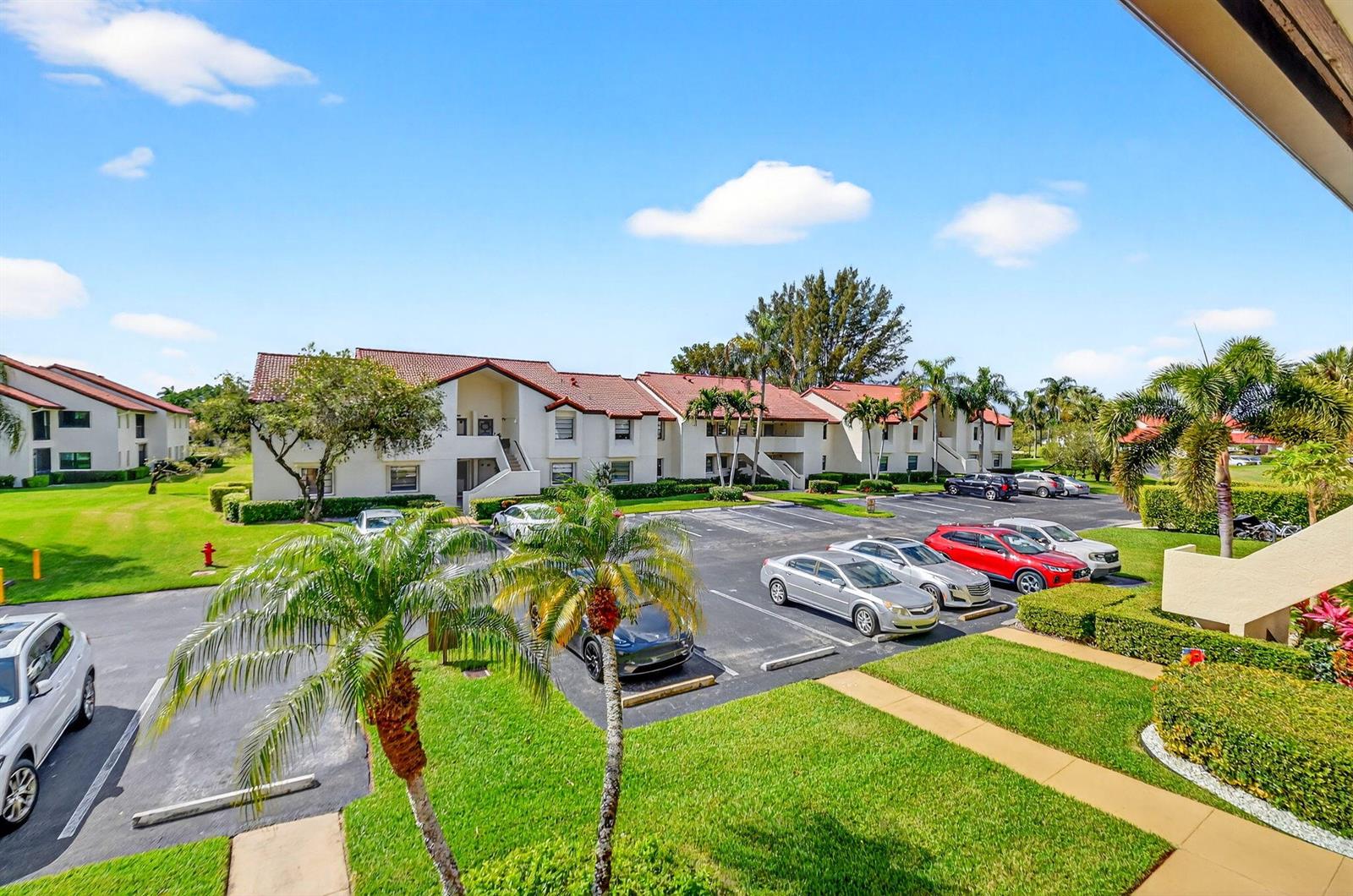 An elevated view of an apartment complex with a parking lot and palm trees — 5903 Parkwalk Drive # 623, Boynton Beach FL 33472, BOYNTON BEACH, FL