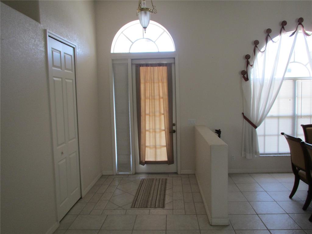 An entryway with tiled floors, a front door with a sidelight, and a half wall — 23404 PEACHLAND BOULEVARD, PORT CHARLOTTE, FL