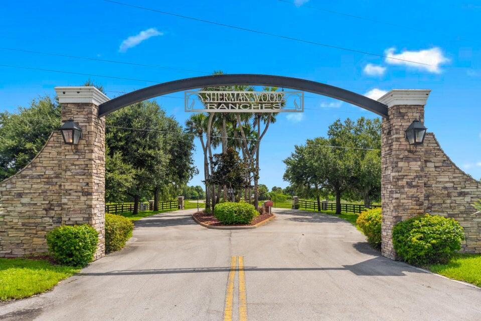 A stone arched entrance gate marks the driveway to Sherman Wood Ranches — 6635 SE 26th Trail, Okeechobee FL 34974, OKEECHOBEE, FL