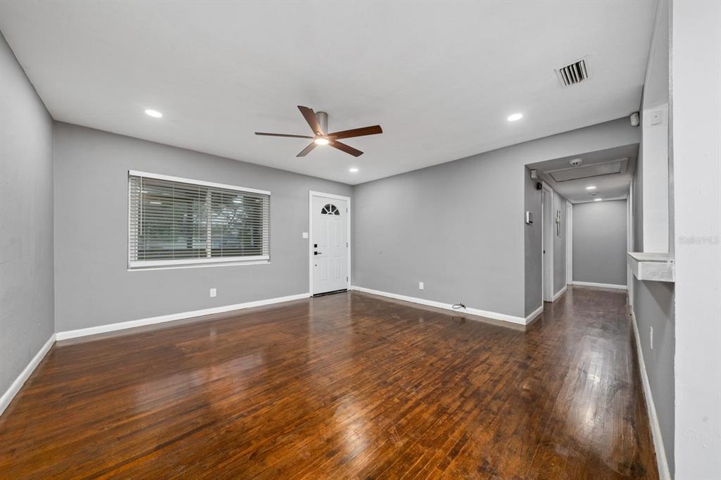 An empty living room features gray walls, dark hardwood floors, and a ceiling fan — 6531 HILL TOP ROAD, ORLANDO, FL