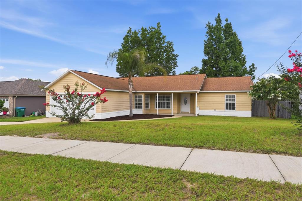 A single-story yellow house with a brown roof, a palm tree, and a front lawn — 2695 KEENE LANE, DELTONA, FL