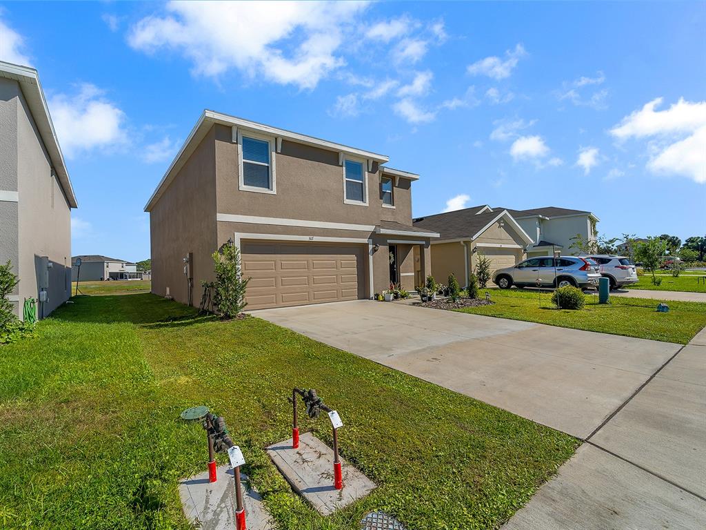 A two-story suburban house with a tan stucco exterior and a two-car garage — 3117 ROCK SOUND STREET, BRADENTON, FL