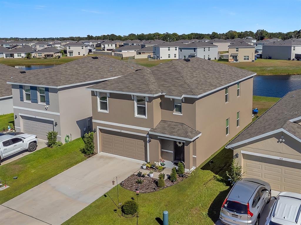 An aerial view shows a two-story tan house with a garage and a landscaped yard — 3117 ROCK SOUND STREET, BRADENTON, FL