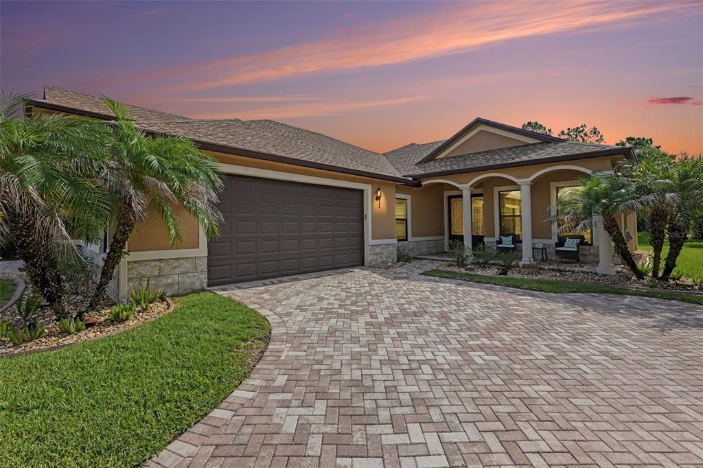 A single-story house with a paved driveway, a two-car garage, and a columned front porch — 429 HARMONY LANE, TITUSVILLE, FL