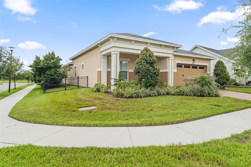 A single-story house with a tan stucco exterior, a two-car garage, and a covered entryway — 2757 SOUTHLAND STREET, ST CLOUD, FL