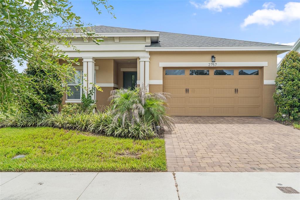 A single-story house with a tan stucco exterior, a two-car garage, and a paved driveway — 2757 SOUTHLAND STREET, ST CLOUD, FL