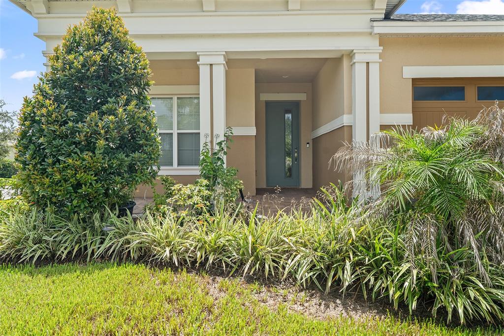 The exterior of a house features a tan facade, a front porch, and landscaping — 2757 SOUTHLAND STREET, ST CLOUD, FL