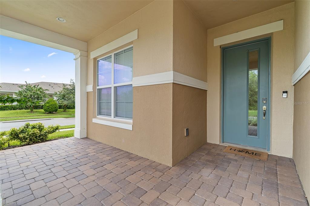 A covered front porch with brick pavers leads to a blue front door — 2757 SOUTHLAND STREET, ST CLOUD, FL