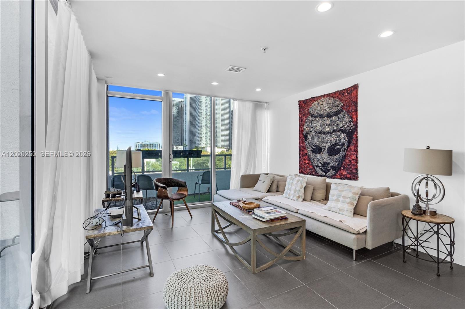 A modern living room features a large sectional sofa, a coffee table, and floor-to-ceiling windows — 3301 NE 1st Ave # M0513, Miami FL 33137, MIAMI, FL