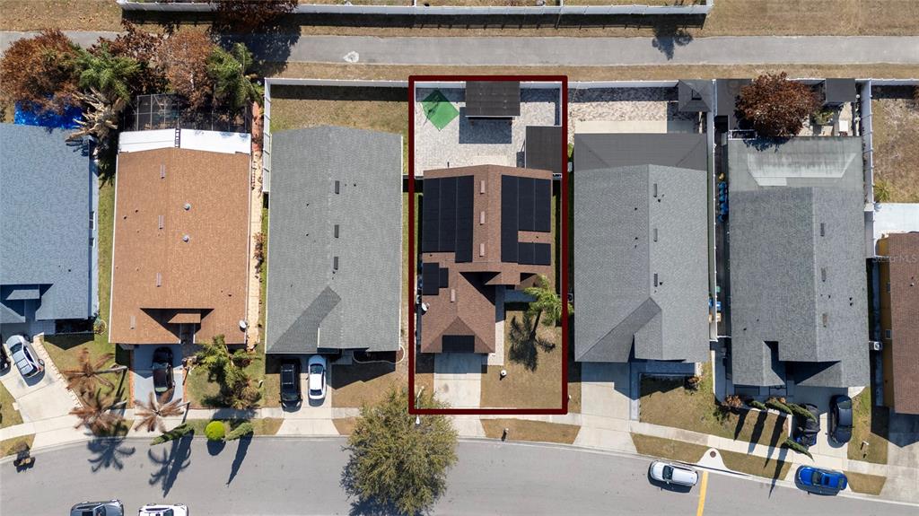 An aerial view shows a residential house with solar panels on its roof and a backyard — 2822 MOULTRIE CREEK DRIVE, KISSIMMEE, FL