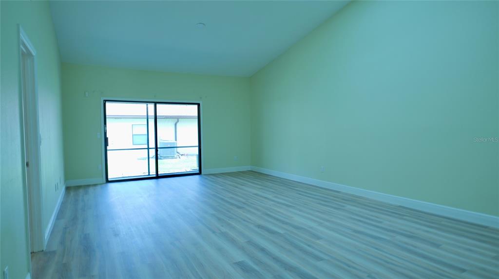 A kitchen features white cabinets, stainless steel appliances, light countertops, and wood-look flooring — 2317 SUN VALLEY CIRCLE UNIT 2317, WINTER PARK, FL