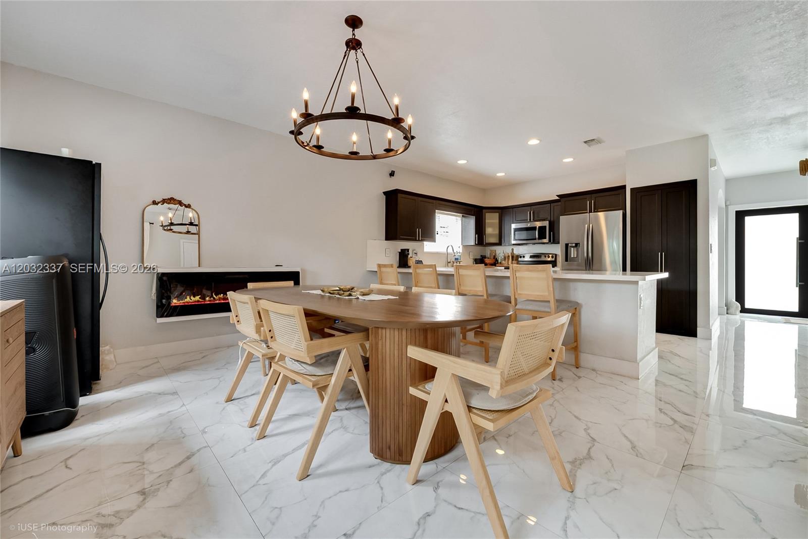 A dining area with a wooden table and chairs sits next to a modern kitchen — 4147 NE 30th St, Homestead FL 33033, HOMESTEAD, FL