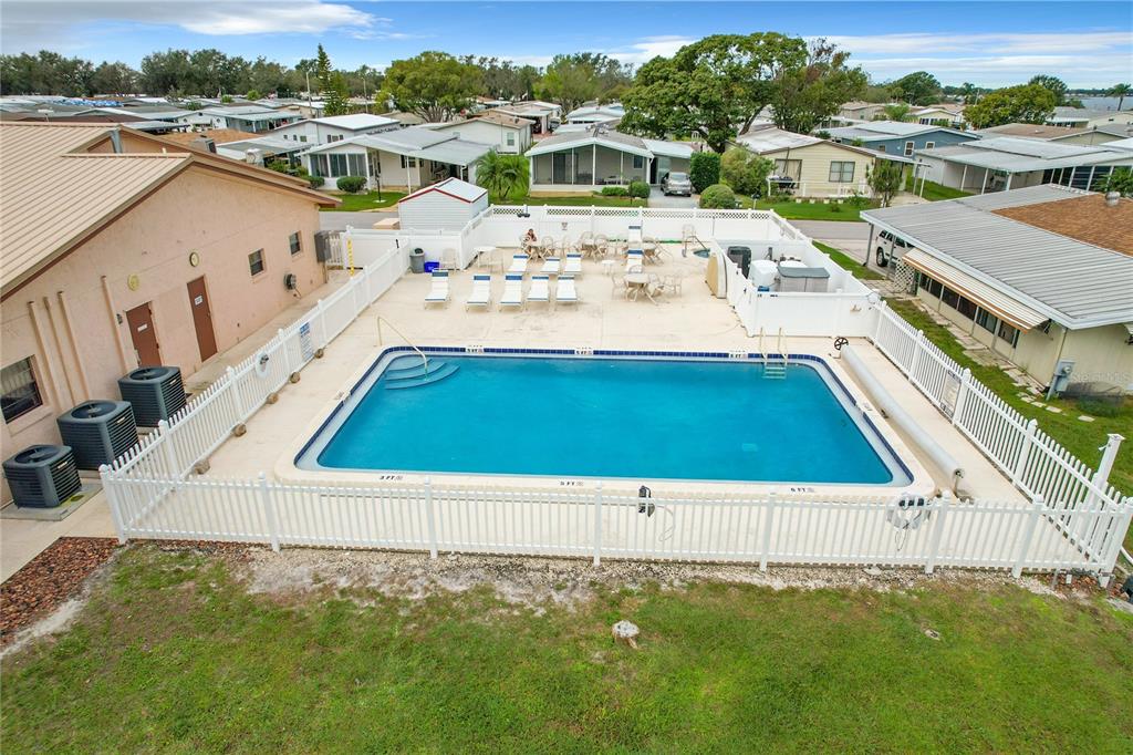 An aerial view of a rectangular swimming pool surrounded by a white fence and lounge chairs — 6775 BRENTWOOD DRIVE NE, WINTER HAVEN, FL
