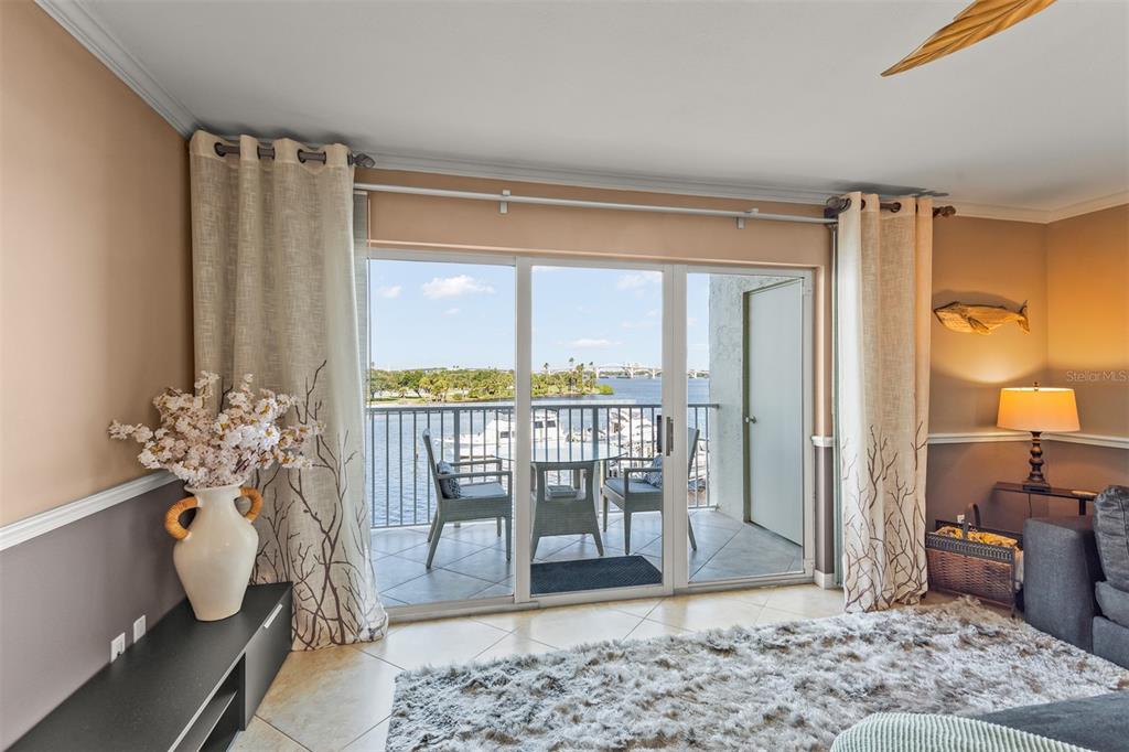 A living room with tile floors, sliding glass doors, and a balcony overlooking the water — 533 MARINA POINT DRIVE UNIT 533, DAYTONA BEACH, FL