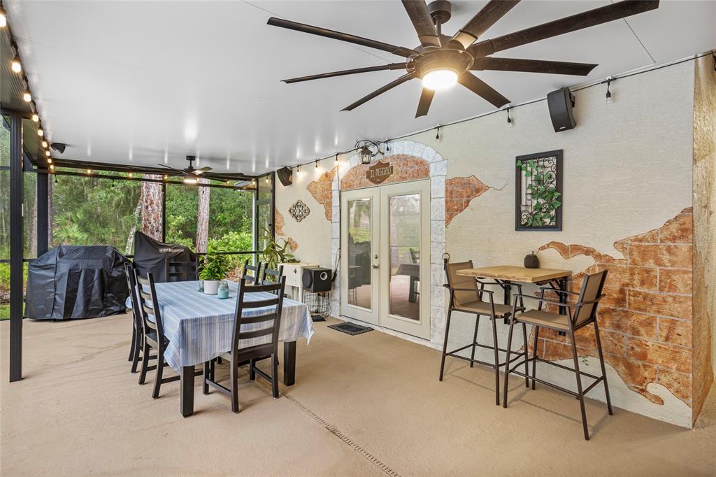 A covered outdoor patio features a dining table, a high-top table, and a ceiling fan — 14612 BRAY ROAD, ORLANDO, FL